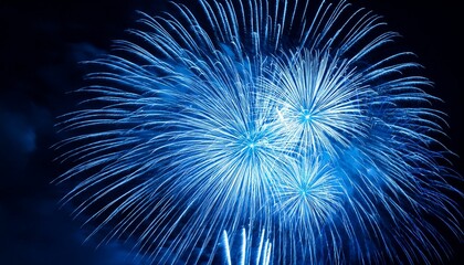 Vibrant blue fireworks light up the night sky.