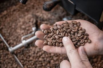 fresh coffee beans roasted spinning cover professional machine close up to soft focus slow shutter speed because want to make motion blur of coffee beans detail concept at factory Nan Thailand