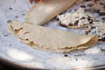 Mexican quesadillas with tomato, squash blossoms and hoja santa (piper auritum) cooked on a traditional griddle over fire.
