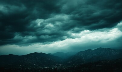 Dramatic stormy clouds over dark mountain range.