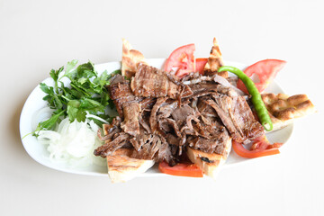 Turkish  Traditional Ramadan doner kebab with tasty tomato sauce and rice or turkish pilav in white plate on table background. Lavash doner kebab ( doner zurna durum )  Pilavustu Doner Iskender kebap