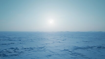 Obraz premium A large, empty, snowy field with a bright sun in the sky