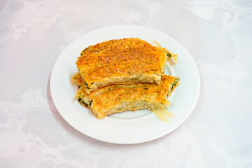 Turkish style meat stuffed filo dough borek served kol boregi.Cheese and minced pie are sliced on a marble background. Turkish name: Kol Boregi, kiymali, peynirli su boregi. Ci borek. Kafkas cig borek