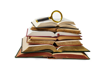 Vintage hard cover books opened and stacked with a magnifying glass on top, isolated on white...