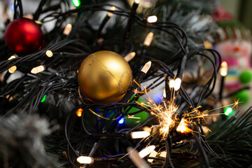 Vintage wire christmas candle lights in a plastic christmas tree,  with hot short circuit sparks  , soft focus close up, fire hazard concept