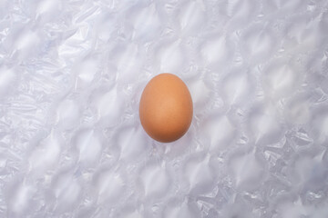 Chicken egg on air cushion bubble wrap background, protection concept