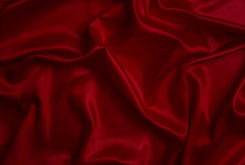 The top view of the red satin surface looks luxurious and beautiful. with sparkling waves Abstract background design copy space Card or banner (blurred or blurry)