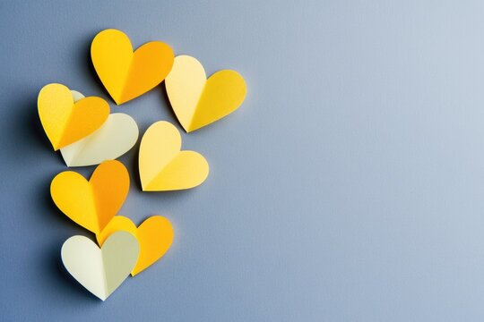 Group of yellow and white paper hearts on a blue surface