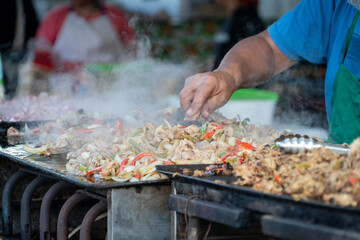 Puesto de comida callejera en Argentina, carnes y verduras salteadas a la plancha