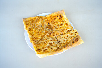 Freshly baked appetizing Turkish tortillas - Gozleme with spinach, cheese  on a wooden board. Space for text. Shallow depth of  field. Handmade traditional  Patatesli, Ispanakli, peynirli gozleme.