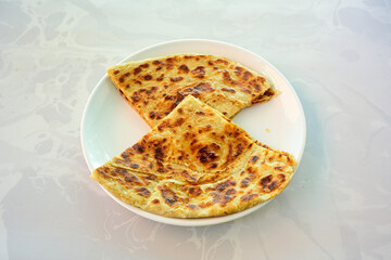 Freshly baked appetizing Turkish tortillas - Gozleme with spinach, cheese  on a wooden board. Space for text. Shallow depth of  field. Handmade traditional  Patatesli, Ispanakli, peynirli gozleme.
