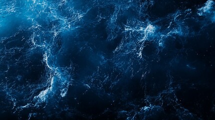 Abstract dark blue water texture with white foam, resembling ocean waves.
