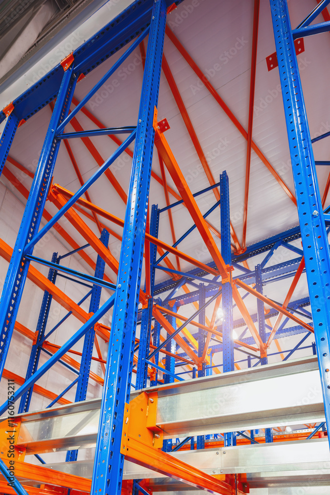 Poster A tall, blue and orange rack system is situated in a large warehouse. The rack system is made up of multiple levels, with each level holding various items