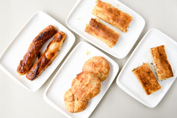 Turkish style meat stuffed filo dough borek served kol boregi.Cheese and minced pie are sliced on a marble background. Turkish name: Kol Boregi, kiymali, peynirli su boregi. Ci borek. Kafkas cig borek