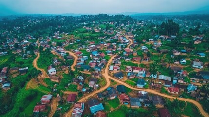 Obraz premium Aerial view of a rural landscape with winding roads and clustered houses amidst greenery.