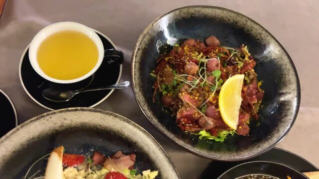 Mixed salad with roast beef and BBQ grapes, Caesar salad with iceberg lettuce, BBQ turkey, bacon and tuna sauce. ramen soup with beef noodles udon eggs green onions soy sauce sesame on a black plate