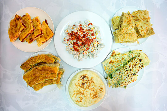 Turkish style meat stuffed filo dough borek served kol boregi.Cheese and minced pie are sliced on a marble background. Turkish name: Kol Boregi, kiymali, peynirli su boregi. Ci borek. Kafkas cig borek