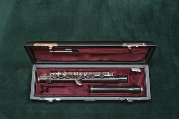 Piccolo flute. Wooden. In case. Lying on a velvet cloth.
