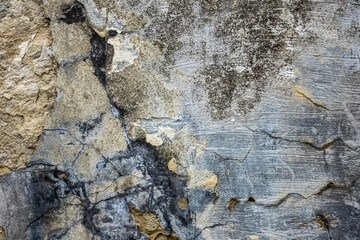 Old peeling brick wall. Wall texture background with remains of plaster and graffiti.