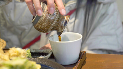 person pouring tea into cup
