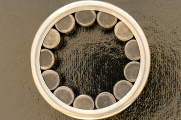 Closeup of a rolling bearing with cylindrical rollers  of an automobile on a black background.