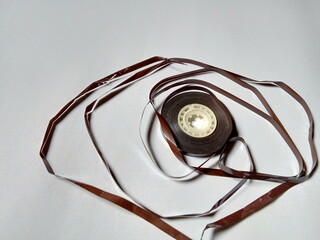 a damaged tape cassette roll, on a white background.