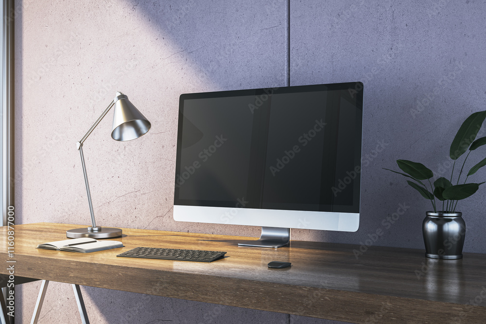 Poster desk setup with computer monitor, lamp, keyboard, notebook, and plant on wooden table near concrete 