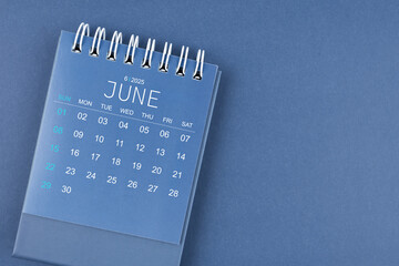 June 2025 calendar on blue color background. Desk calendar for planning.