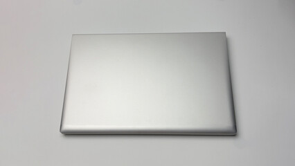 A white laptop is on a white background. The laptop is the main focus of the image. The background is plain and simple, with no other objects or distractions. Concept of focus and productivity