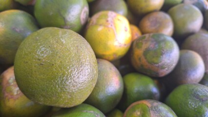 A collection of green oranges in the photo from above