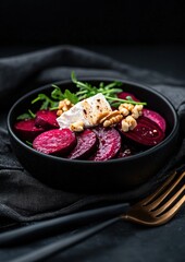 A bowl of food with beets, walnuts, and cheese