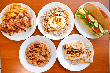 Delicious meat kebab with fresh vegetable salad served with variety of Turkish dishes and appetizers. Top view of assorted Turkish food and meze, tasty and healthy Mediterranean cuisine.