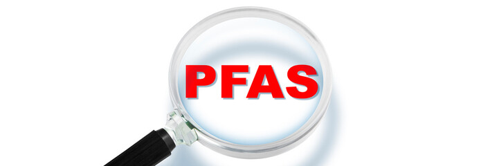 PFAS text with copy space - Dangerous Perfluoroalkyl and Polyfluoroalkyl substances used in products and materials due to their enhanced water-resistant properties - Concept with magnifying glass