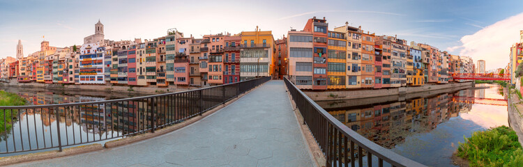 Panoramic view of Girona's colorful riverside buildings and cathedral in Catalonia, Spain.