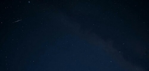 Fototapeta premium The night sky has shooting a star and the Milky Way in the background.