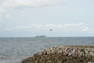 A thrilling parasailing adventure over the open sea, with a colorful parachute gliding above the...