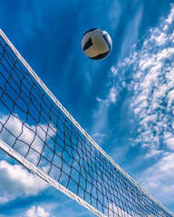 Dramatic shot of a volleyball net with a ball caught mid-air above it, under a vibrant blue sky