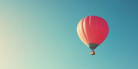 Fototapeta premium Hot air balloon captured soaring high against a bright blue cloudless sky, showcasing the beauty and freedom of hot air balloon adventures in the open air.