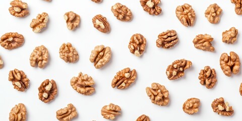 Obraz premium A multitude of walnut seeds displayed, showcasing isolated nuts on a clean white background, offering a top view perspective of these delicious walnut seeds. Ideal for culinary themes.