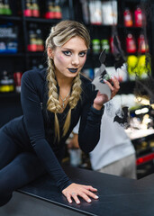 Model in Halloween black wear. A model poses in a dark outfit, showcasing Halloween decorations and makeup in a vibrant retail setting.