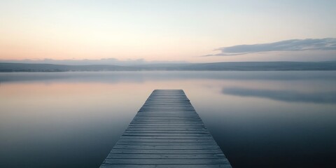 A solitary wooden jetty extends into a serene saltwater lake during the tranquil early morning hours, just before dawn, creating a peaceful atmosphere around the wooden jetty.