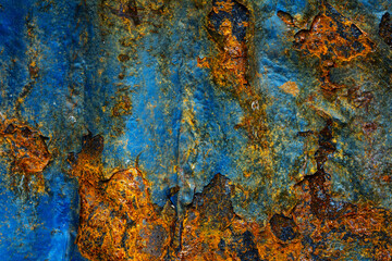 Rusty metal surface with shabby background paint. Blue cracked paint texture on an iron sheet. Fragment of an old metal door, Metal corrosion.