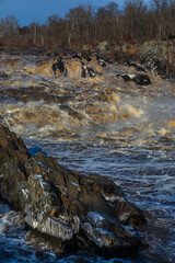 The powerful Potomac River at the Great Falls Park, National Park in Virginia, with Rocks in...