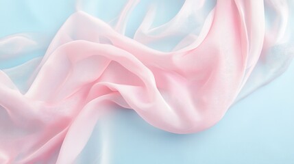 Fototapeta premium Delicate soft pink fabric gracefully draped on a serene pale blue background creating an elegant and tranquil visual atmosphere