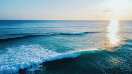 Obraz premium Gentle ocean waves create a serene rippling surface reflecting warm sunlight and a tranquil sky at sunset over the horizon.