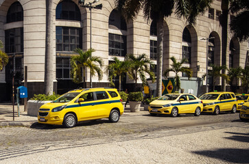 Yellow taxis parked in a vibrant street of Rio de Janeiro during daylight hours
