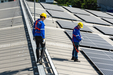 Two solar engineers men working on solar panels roof