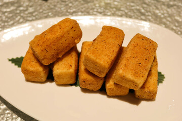 close up of chinese deep fried crispy salt and pepper tofu bean curd on a white plate with copy space