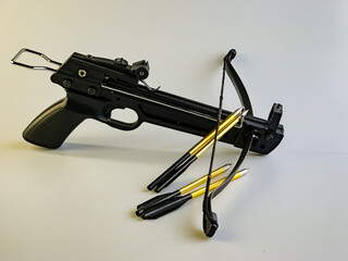 Black training crossbow with black string and arrows on a white background.