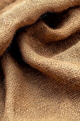 Fototapeta premium A close-up of textured burlap fabric showcasing its natural, coarse weave and earthy tones, perfect for rustic decor and crafting projects.